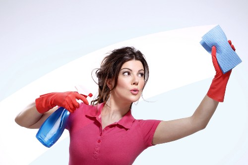 Local technician cleaning a corner sofa in a Wimbledon home